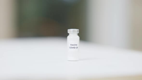 Covid19 Vaccine Ampoule Standing on Table in Medical Cabinet alt