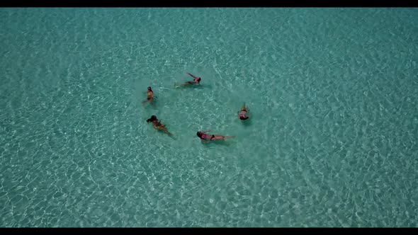 Female models posing on tranquil coastline beach voyage by blue sea and clean sandy background of th alt