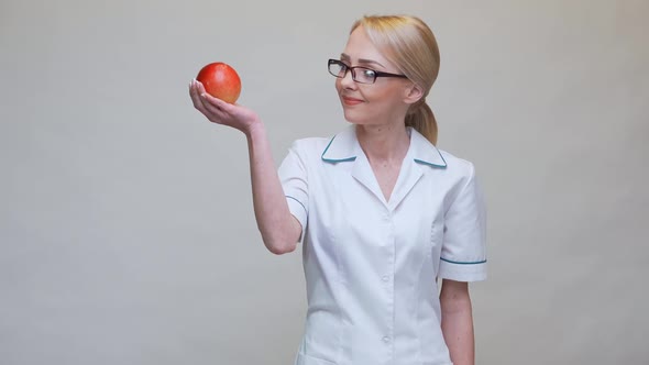 Nutritionist Doctor Healthy Lifestyle Concept - Holding Organic Red Apple and Measuring Tape alt