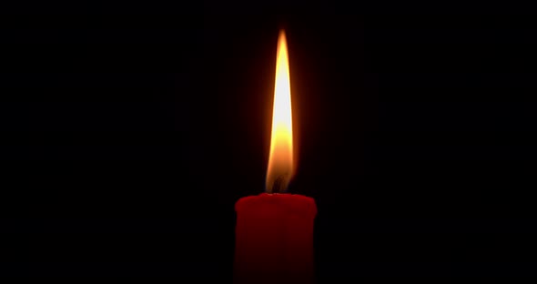 Burning Red Candle on a Black Background