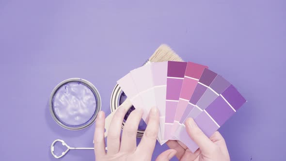 Close up of metal paint can with purple paint and paint swatch. alt