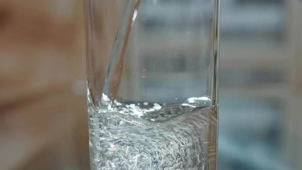 Mineral Water Is Poured Into a Glass From the Bottle Close Up, Moving Camera