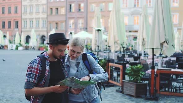 Young Man and Woman Looking on Main Tourist Attractions Using Map alt
