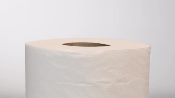 Toilet roll rotating slowly, isolated on white background, rotation