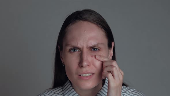 Portrait of Female Popping Pimple alt