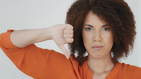 Headshot Portrait Indoor Displeased Millennial Woman with Curly Hair Looking at Camera Showing alt