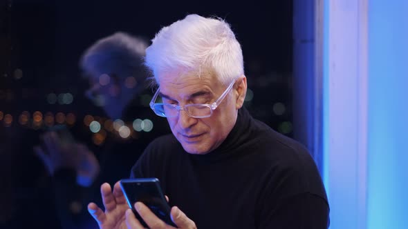 Old Senior Gentleman in Glasses with White Gray Hair Searching Via Smartphone