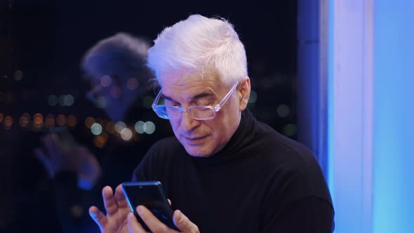 Old Senior Gentleman in Glasses with White Gray Hair Searching Via Smartphone alt