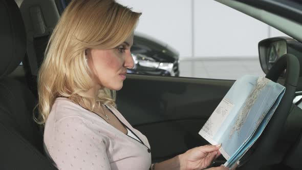 Gorgeous Mature Woman Looking at the Map Sitting in a Car alt