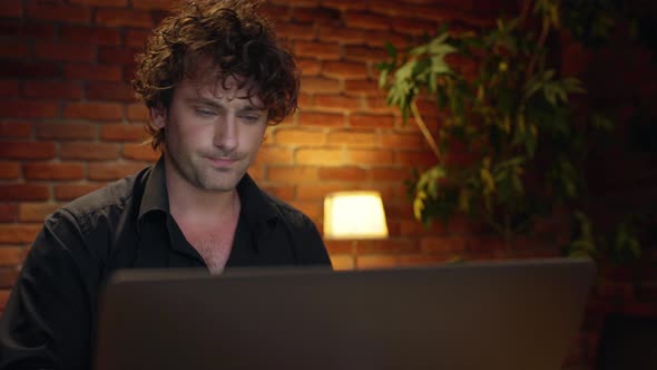 Displeased Young Successful Businessman Speaking on Phone Working in Office at Night alt