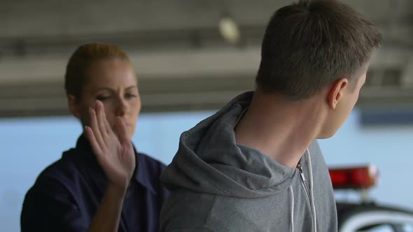 Woman Officer Detaining Aggressive Dealer, Putting Handcuffs and Taking to Car alt