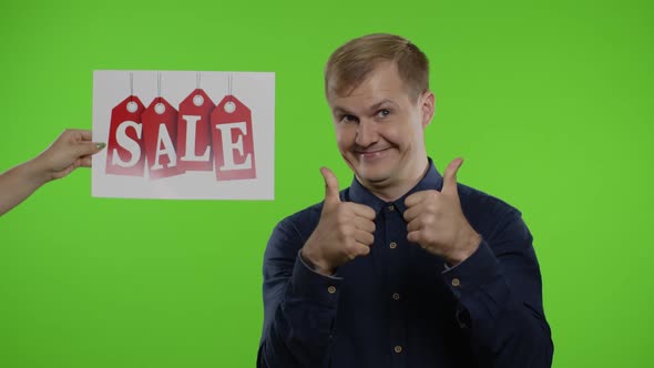 Inscription Sale Word Appears Next To Smiling Man. Guy Showing Thumbs Up. Shopping on Black Friday alt