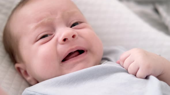 Dissatisfied Crying Upset Sad Newborn Baby Boy Lying in Nursery Cocoon ...