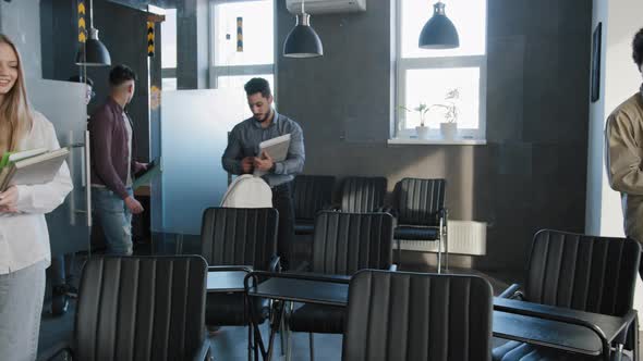 Diverse Team Happy Smiling Young Students Enter Classroom Sit Down at Their Desks Prepare for Lesson alt