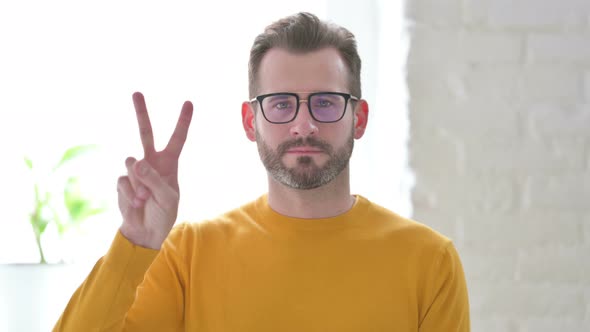 Portrait of Man Showing Victory Sign with Finger alt