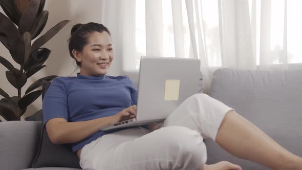 Asian businesswoman authentic shot using a laptop to work from home happily alt