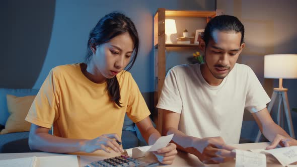 asia man and woman use calculator for calculate family budget debts monthly expenses.