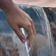 Woman Slender Hand Relaxedly Touches the Water in a Waterfall on a Evening - VideoHive Item for Sale
