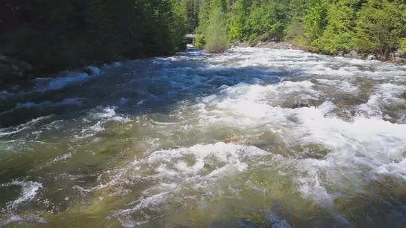 Aerial Drone Traveling Along Water Rapids With Mountains And Evergreen Forest 2