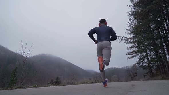 Following Fitness Man Jogger Training Outdoors in Foggy Autumn Day alt