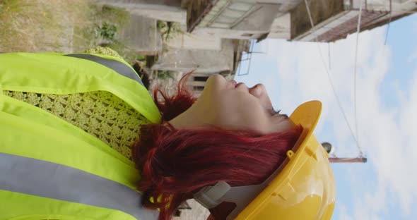 Vertical video of an engineer girl looking at the city destroyed by the earthquake alt