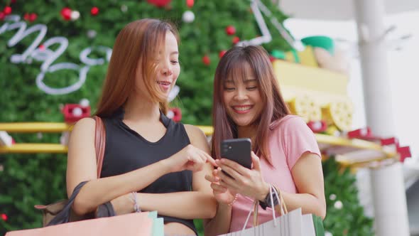Asian young women  holding shopping bag and phone, shopping in department store during sale season alt