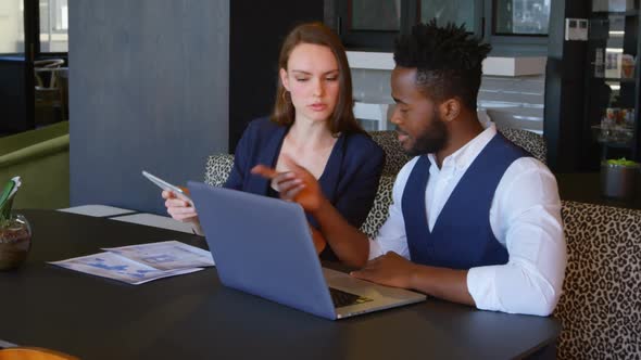 Front view of young cool mixed-race business team planning and sitting at table of modern office 4k alt