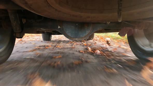 Rear Wheels of SUV Truck Spinning and Move on Off Road Terrain with Dusk Dirty Earth and Blurry alt