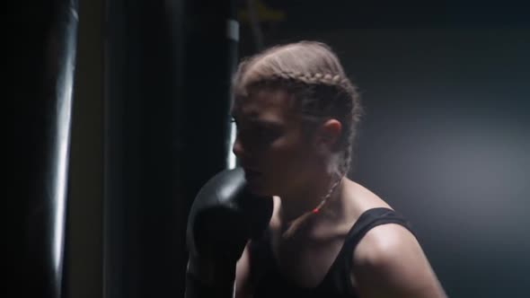 Kickboxing Aggressive Woman Fighter Trains His Punches Beats a Punching Bag Training Day in the alt