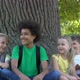 Cheerful Group of Children Joking Laughing Together Sitting Park Under Tree - VideoHive Item for Sale