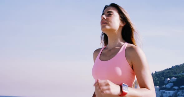 Fit woman jogging on the beach alt