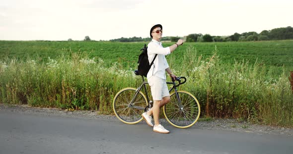 Man Walking with Bike on Field