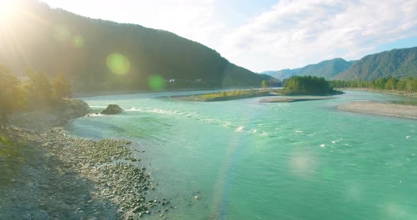 Low Altitude Flight Over Fresh Fast Mountain River with Rocks at Sunny Summer Morning. alt