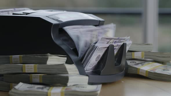 Closeup shot of money counting machine with 100 dollar bills.
