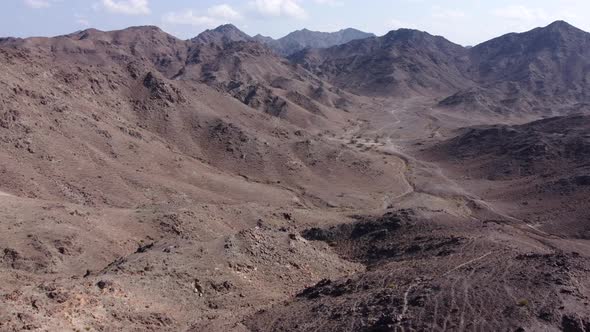 Aerial Flying in Dry Rocky Rugged Mountains. Arabian Desert Landscape. alt