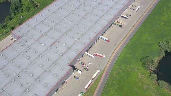 Big Distribution Warehouse Gates Loads Trucks Reversing Loading Dock Aerial alt