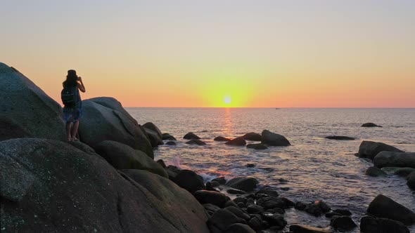 Aerial View A Lady Standing Watching Sunset On The Large Rock. alt