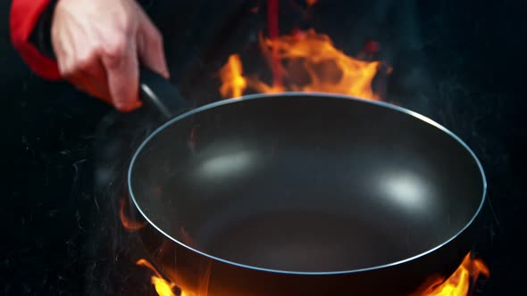 Super Slow Motion Shot of Chef Holding Empty Frying Pan and Flames at 1000Fps alt