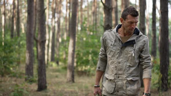 Medium Shot Concentrated Adult Man Walking in Spring Summer Forest Looking Around alt