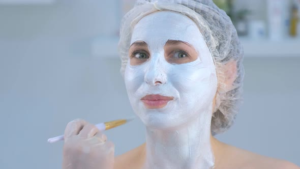 Cosmetologist is Applying Facial Moisturizing Mask on Woman Face Using Brush