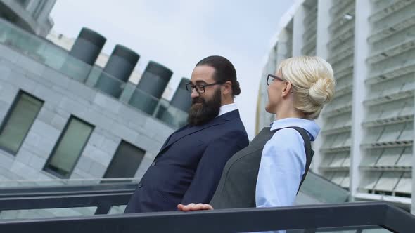 Smiling Man and Lady in Office Suits Walking Downstairs and Chatting, Rest Time