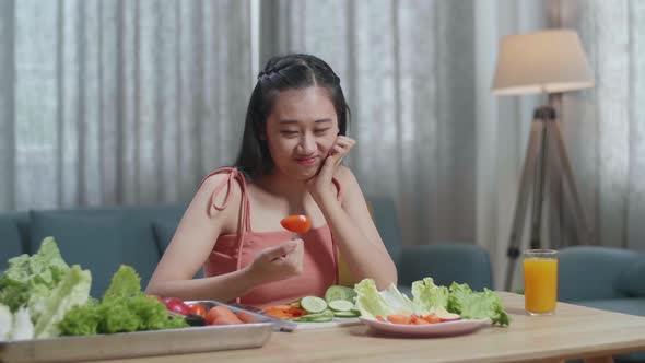 Asian Woman Holding Her Cheek And Shaking Her Head Due To Hating Eating Healthy Food alt