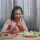 Asian Woman Holding Her Cheek And Shaking Her Head Due To Hating Eating Healthy Food - VideoHive Item for Sale