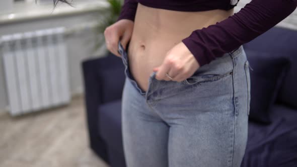 Overweight Woman Measuring Waist with Too Small Jeans Pulling Up Tight Jeans