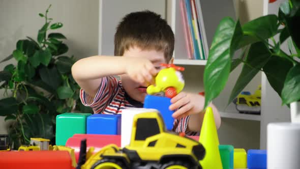 A Preschool Boy Plays a Helicopter Sitting at a Table Cubes and Cars for Children alt
