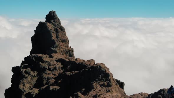 Aerial View. A Young Couple Stands on the Edge of the Cliffs Above the Clouds