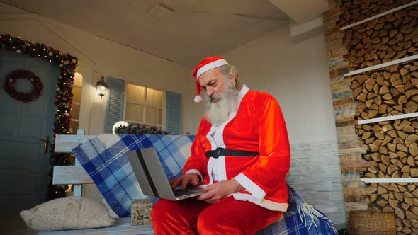 Gracious Santa Claus Working on Laptop.