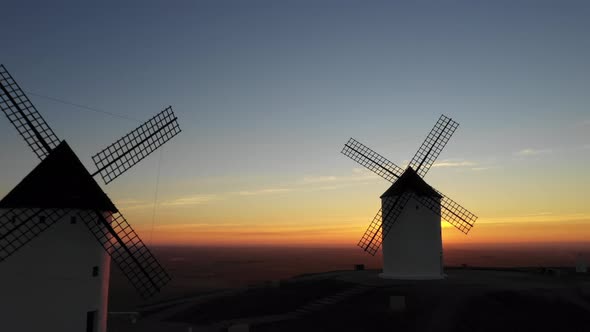 Aerial view of windmills in the countryside in Spain at sunrise alt