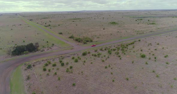 Aerial view of a red car driving on country road