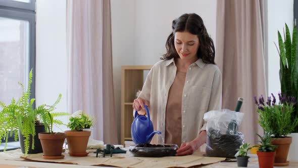 Woman Watering Soil in Vase for Flowers at Home